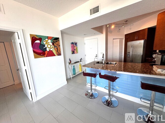 A kitchen with a bar stool in front of a counter.