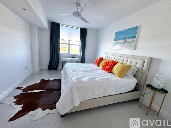 A bedroom with a large bed and a cowhide rug.