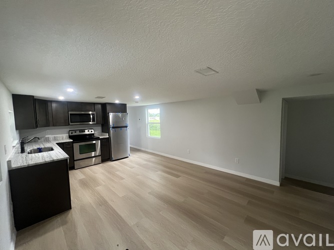 A kitchen with a refrigerator, microwave, and oven.