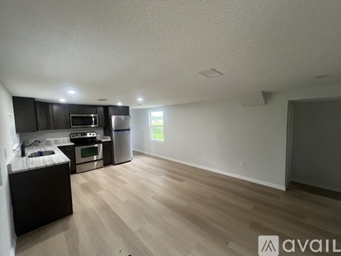A kitchen with a refrigerator, microwave, and oven.