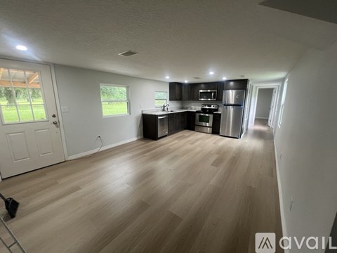 A kitchen with wooden floors and stainless steel appliances.
