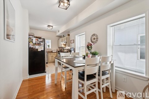 A kitchen with a dining table and chairs in the foreground.