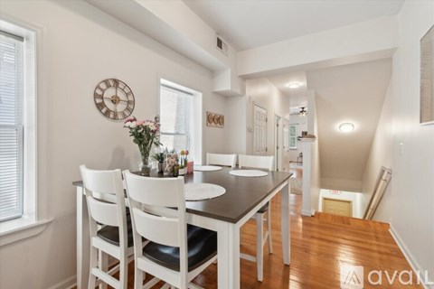 A dining room with a table set for four.