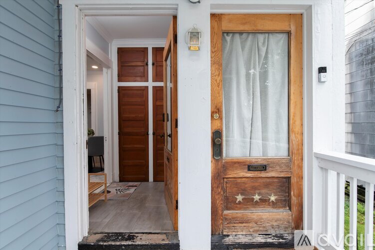 A blue house with a wooden door and a glass window.