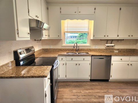 A kitchen with white cabinets and a granite countertop.