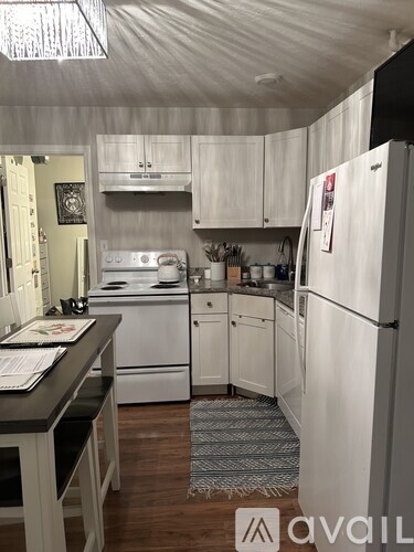 A kitchen with white appliances and cabinets.