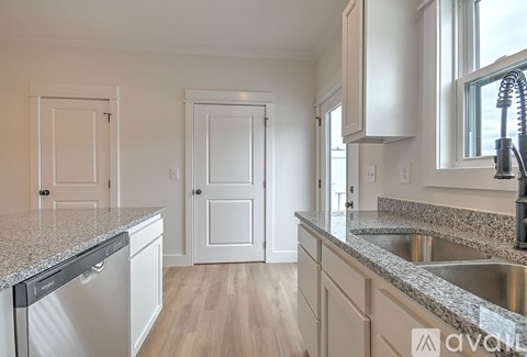 A kitchen with a sink, dishwasher, and cabinets.