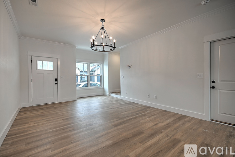 A large, empty room with wooden floors and white walls.