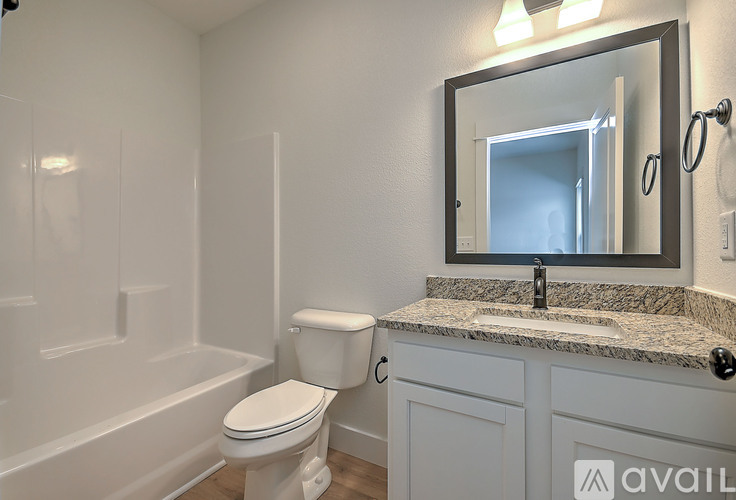 A bathroom with a toilet, sink, and mirror.