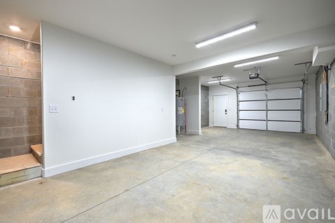 A spacious garage with a white wall and a brick column.