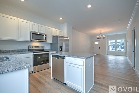 A kitchen with white cabinets and a granite countertop.