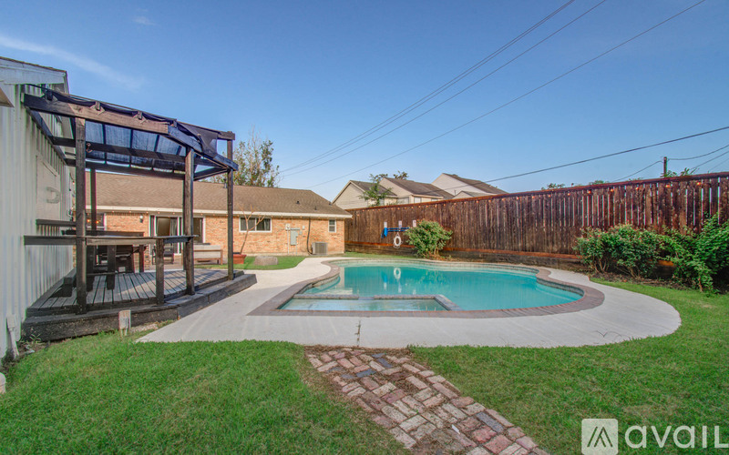 A backyard with a pool and a deck.