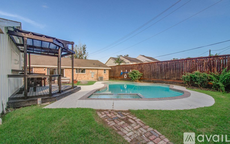 A backyard with a pool and a deck.