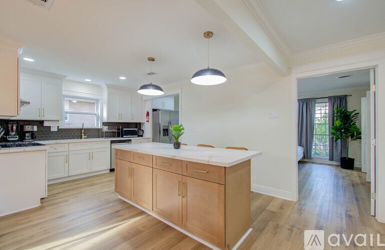 A kitchen with wooden floors and a central island.