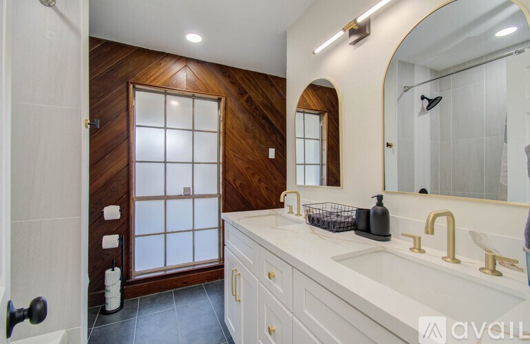 A bathroom with a wooden door and a white sink.