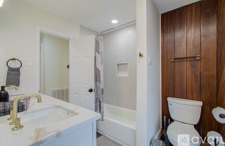 A white bathroom with a sink, toilet and bathtub.