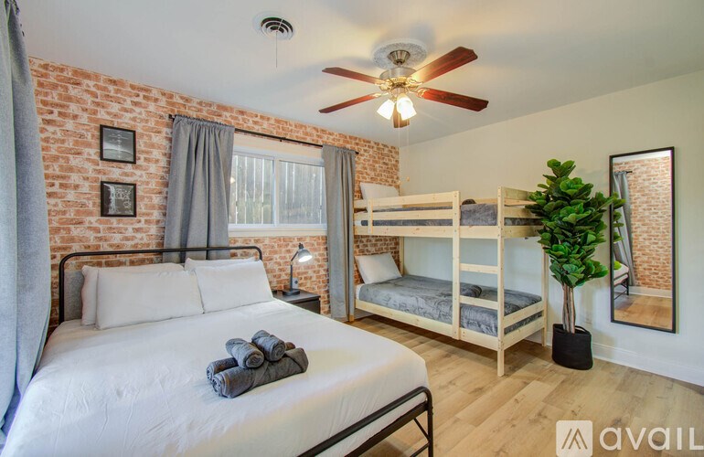 A bedroom with a brick wall and a bunk bed.
