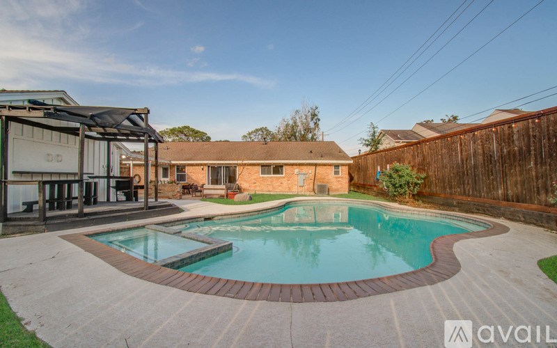 A backyard with a pool and a deck.
