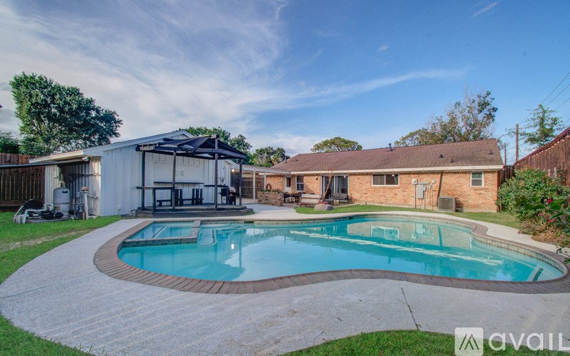 A backyard with a swimming pool and patio furniture.