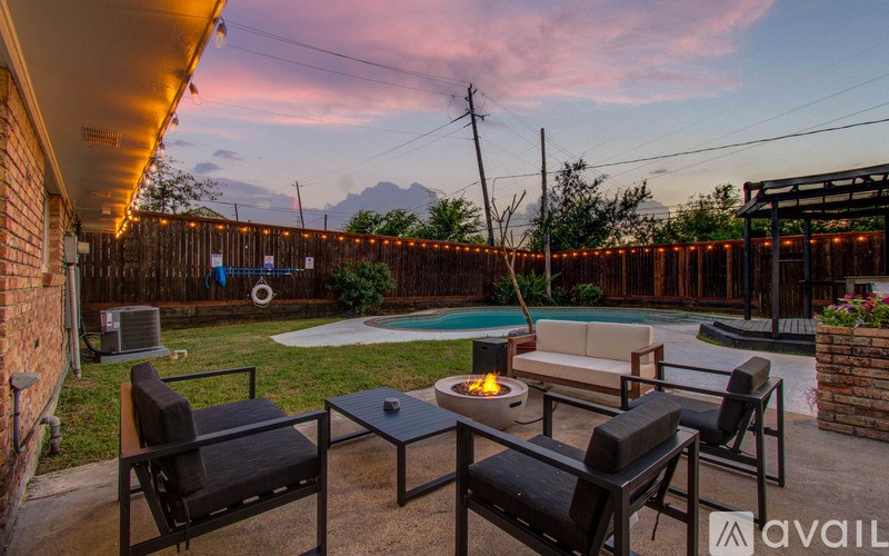 A backyard with a pool table and chairs.