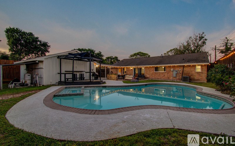 A backyard with a pool and a house.