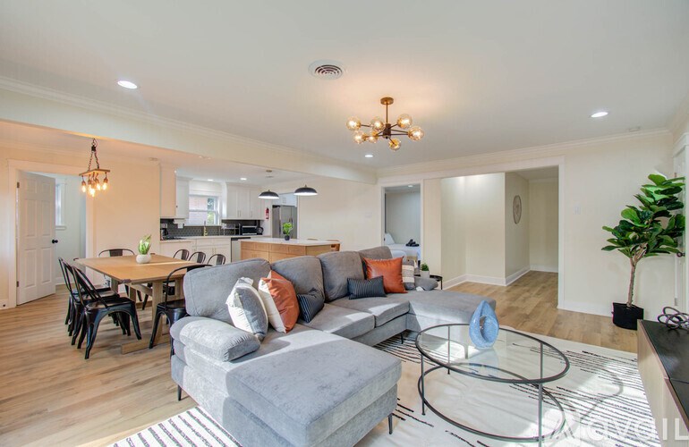 A modern living room with a grey sofa and a glass coffee table.