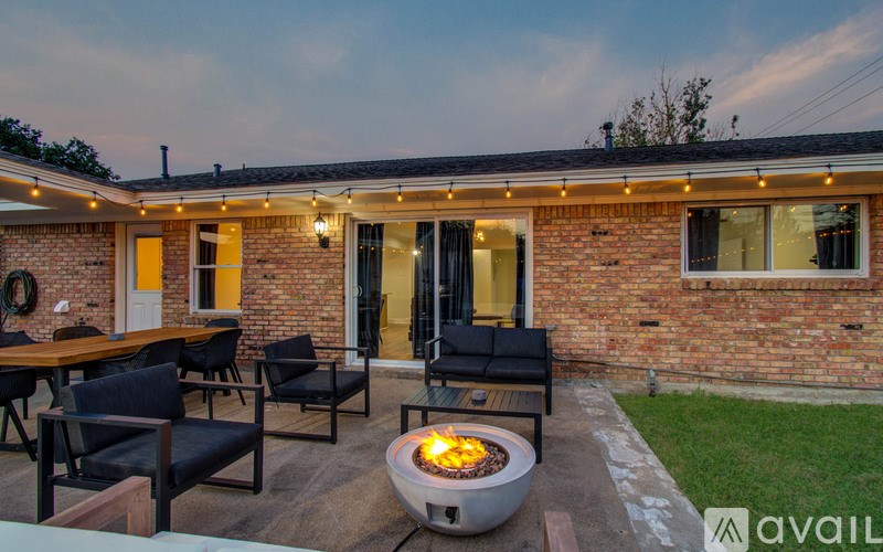A patio with a fire pit and chairs.
