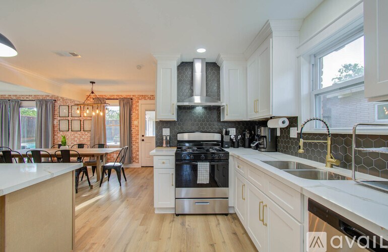 A modern kitchen with a stove top oven and a dining table with chairs.