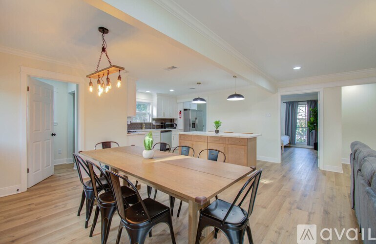 A dining room with a long wooden table and chairs.