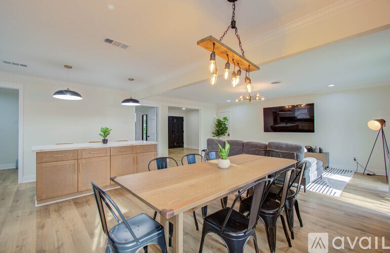 A modern dining room with a wooden table and chairs.