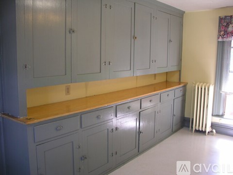 A kitchen with grey cabinets and a yellow countertop.