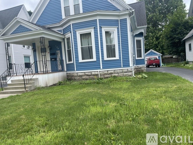 A blue house with a red car parked in front.