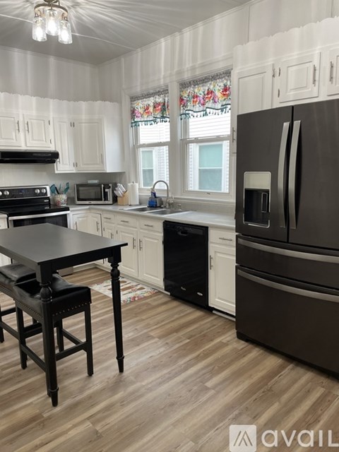 A kitchen with a black table and a black fridge.
