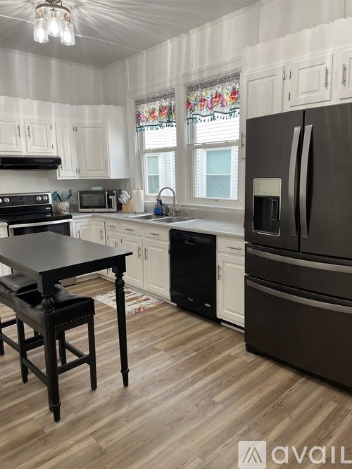 A kitchen with a black table and a black fridge.