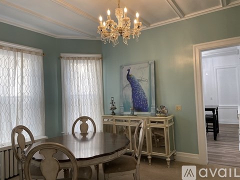 A dining room with a wooden table and chairs.