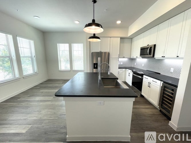 A kitchen with a black countertop and white cabinets.