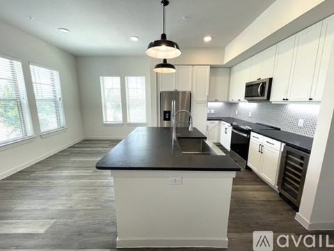 A kitchen with a black countertop and white cabinets.