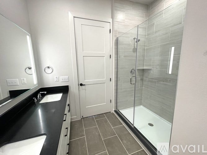 A bathroom with a sink, mirror, and shower.