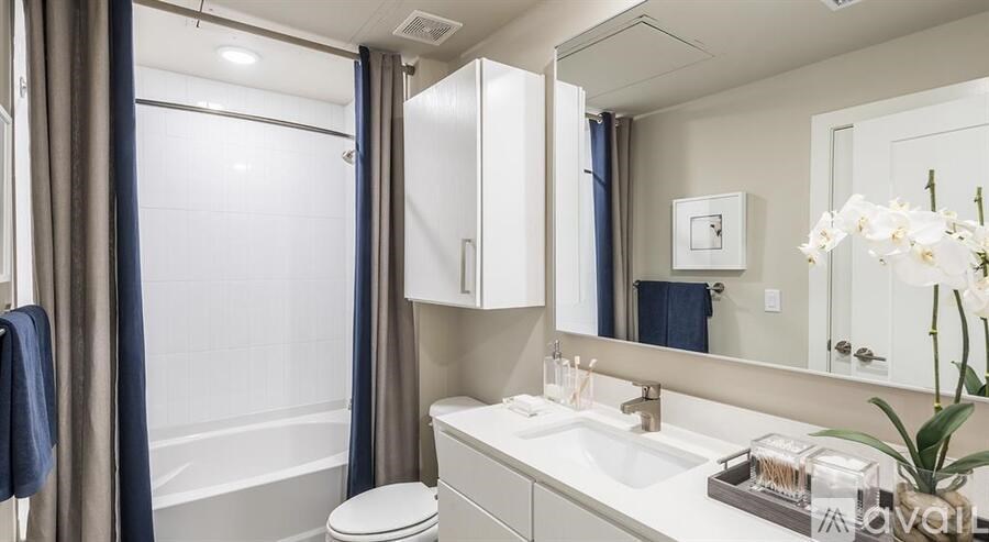 A bathroom with a white sink, toilet, and a large mirror.