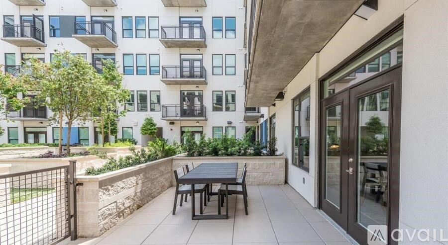 A patio with a table and chairs is in front of a building.