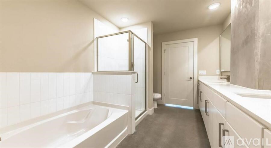 A bathroom with a tub, sink, and mirror.