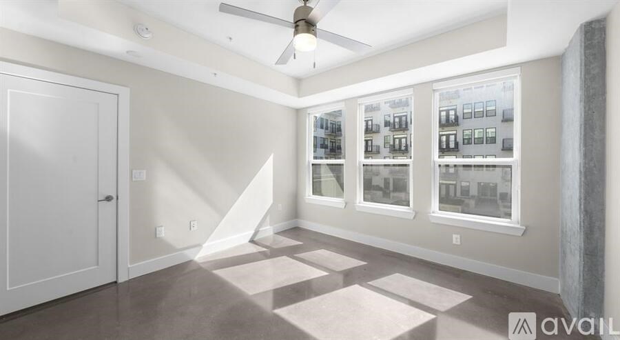 A room with a ceiling fan and a wall of windows.