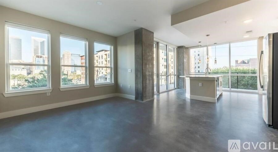 A spacious room with large windows and a view of the city.