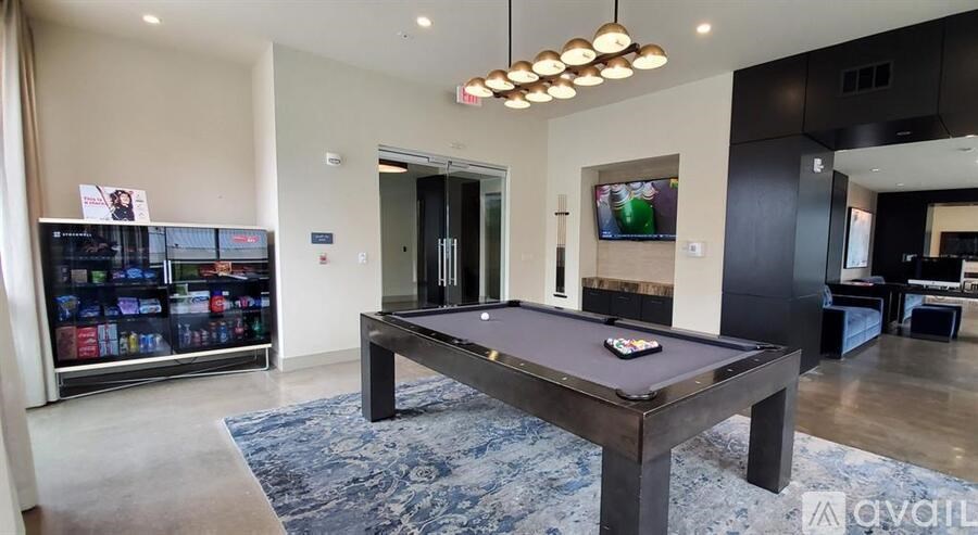 A room with a pool table and a TV on the wall.