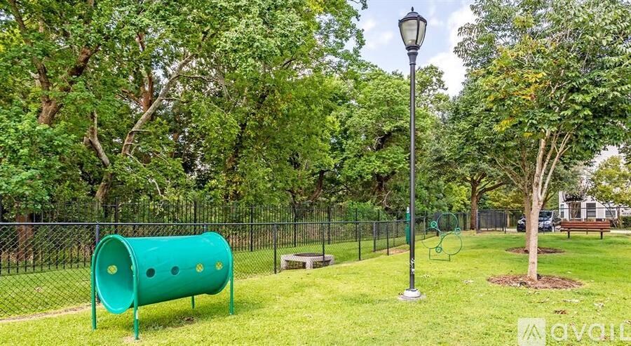A playground with a green slide and a lamp post.