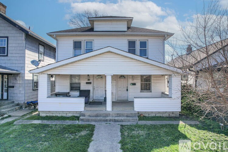 A two-story house with a front porch is for sale.