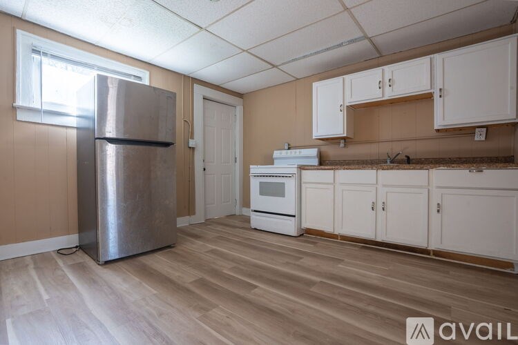 A kitchen with a refrigerator, oven, and cabinets.