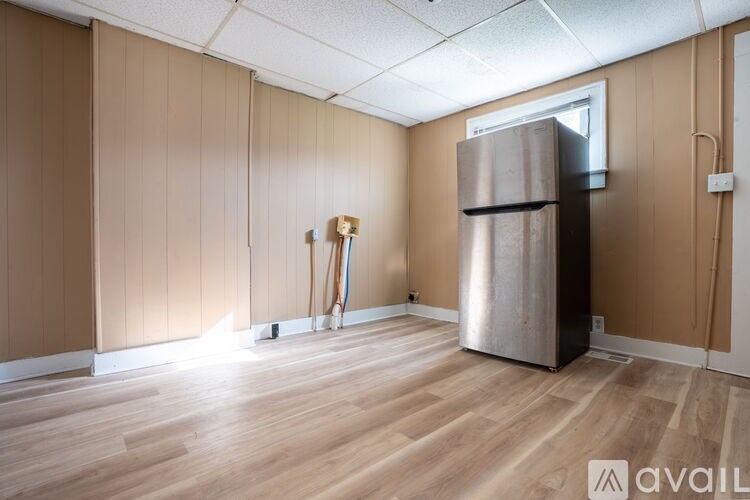 A room with wooden floors and a wall-mounted refrigerator.