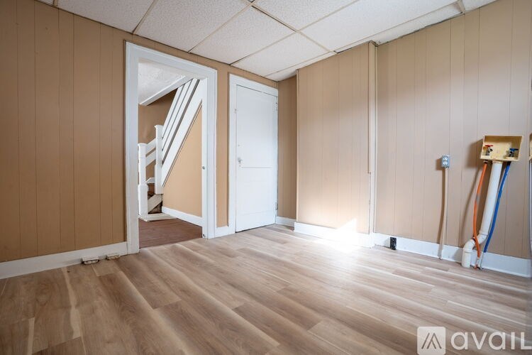 A room with wooden flooring and a white door.