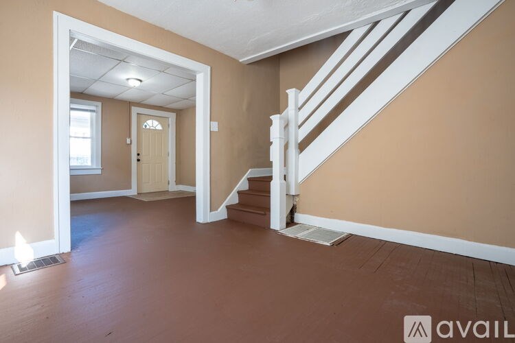 A room with a staircase leading to another room.